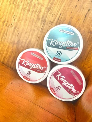 Kingston-nicotine-pouches Kingston nicotine pouches in different nicotine strengths and a variety of flavours on wood background