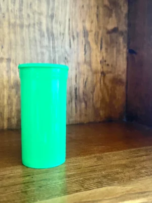 Dram Pop Top Storage Bottles In green on wood background