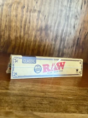 Raw classic rolling papers on wood background